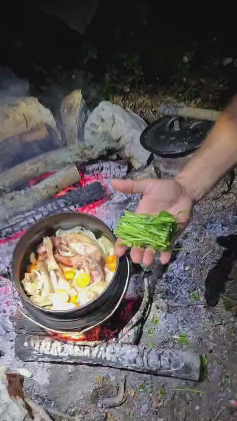 Chaudron en fonte sur un feu de bois avec un ragoût de lapin médiéval qui mijote.