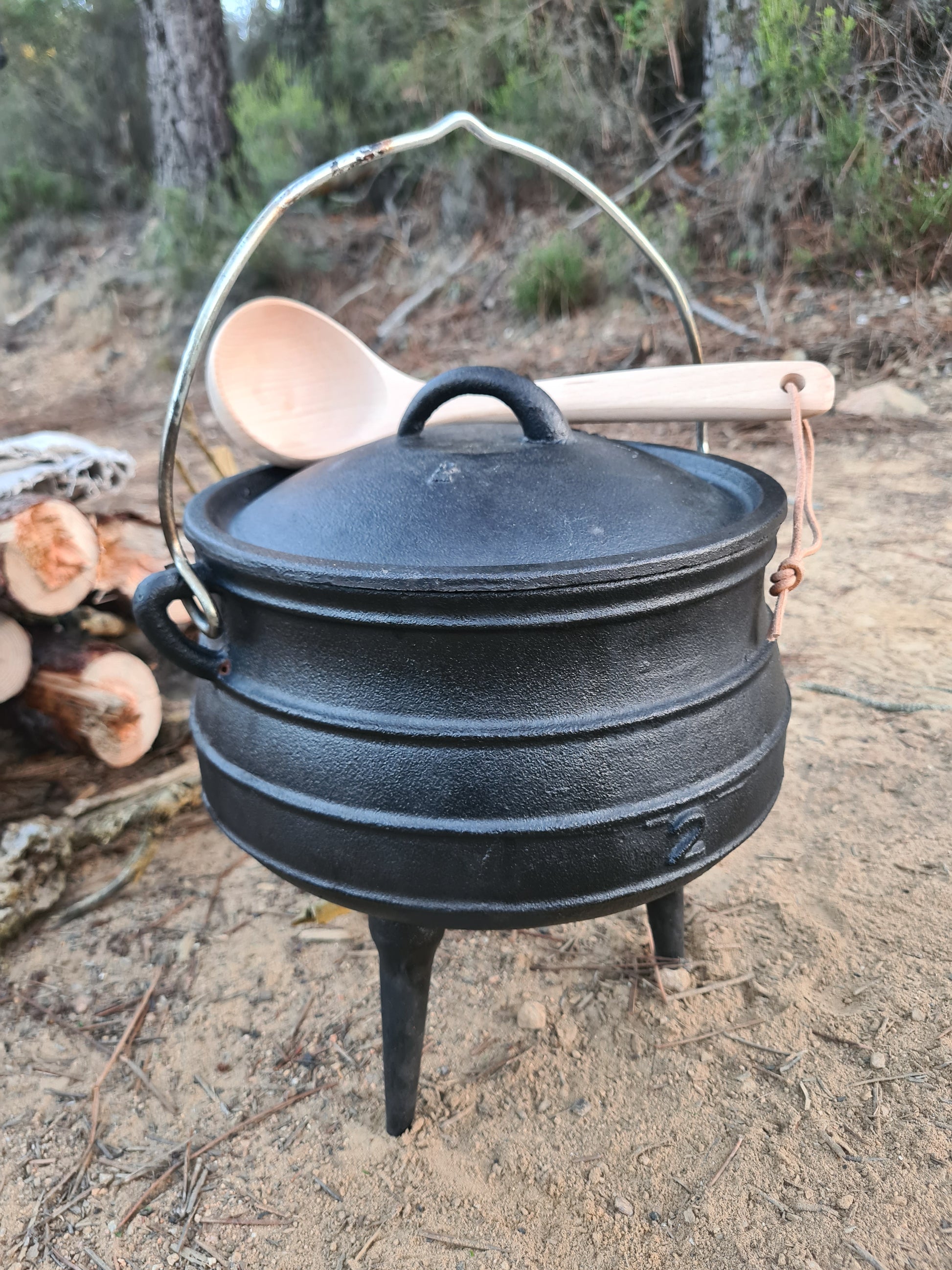 Photo d'un chaudron et louche en bois pour cuisiner en liberté.