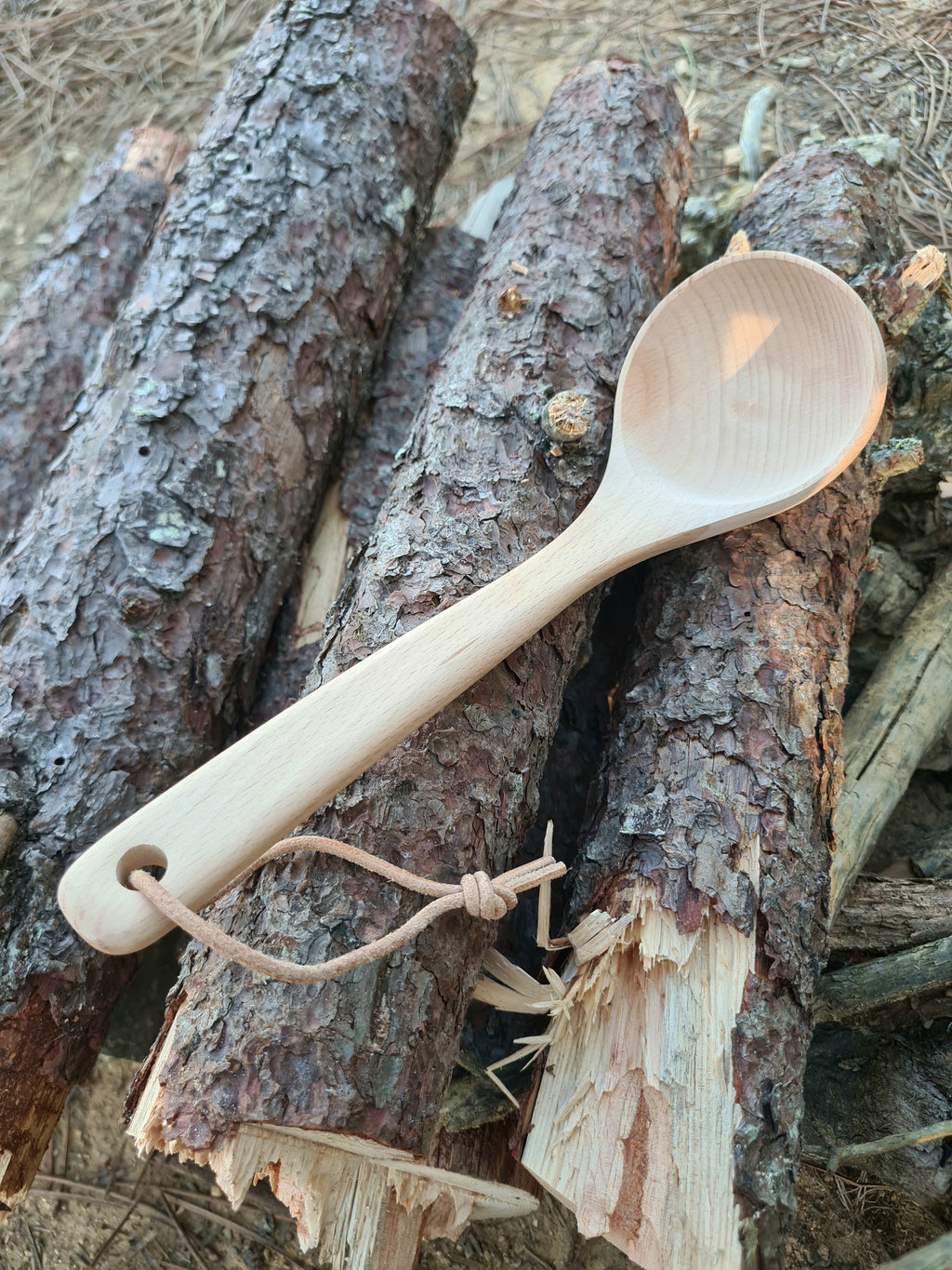 Louche en bois de Hêtre naturel FSC posée sr des rondins de bois coupés. approche libre, pour ceux qui vivent en liberté.